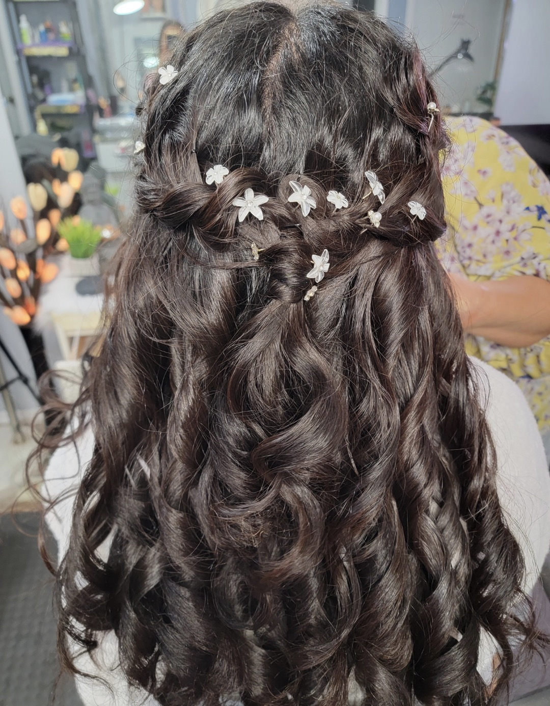 Graduation updo: twisted half-crown with soft curls and white flower pins