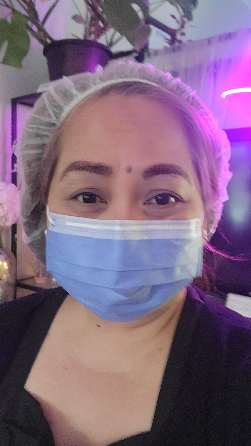 Jasmin in a hairnet and mask, ready for a treatment