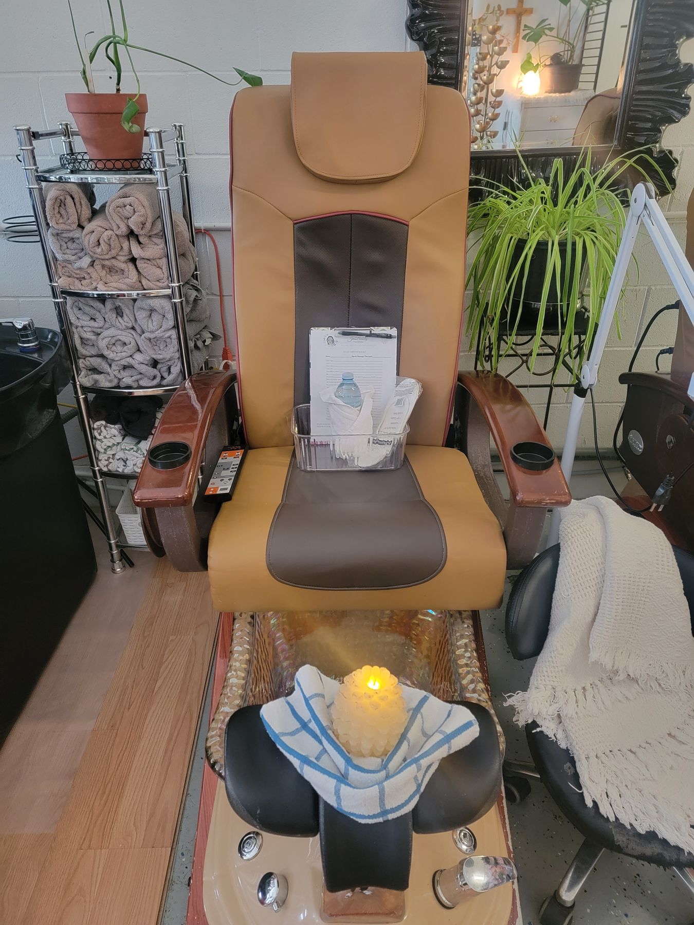 Pedicure chair set with rolled towels and a candle