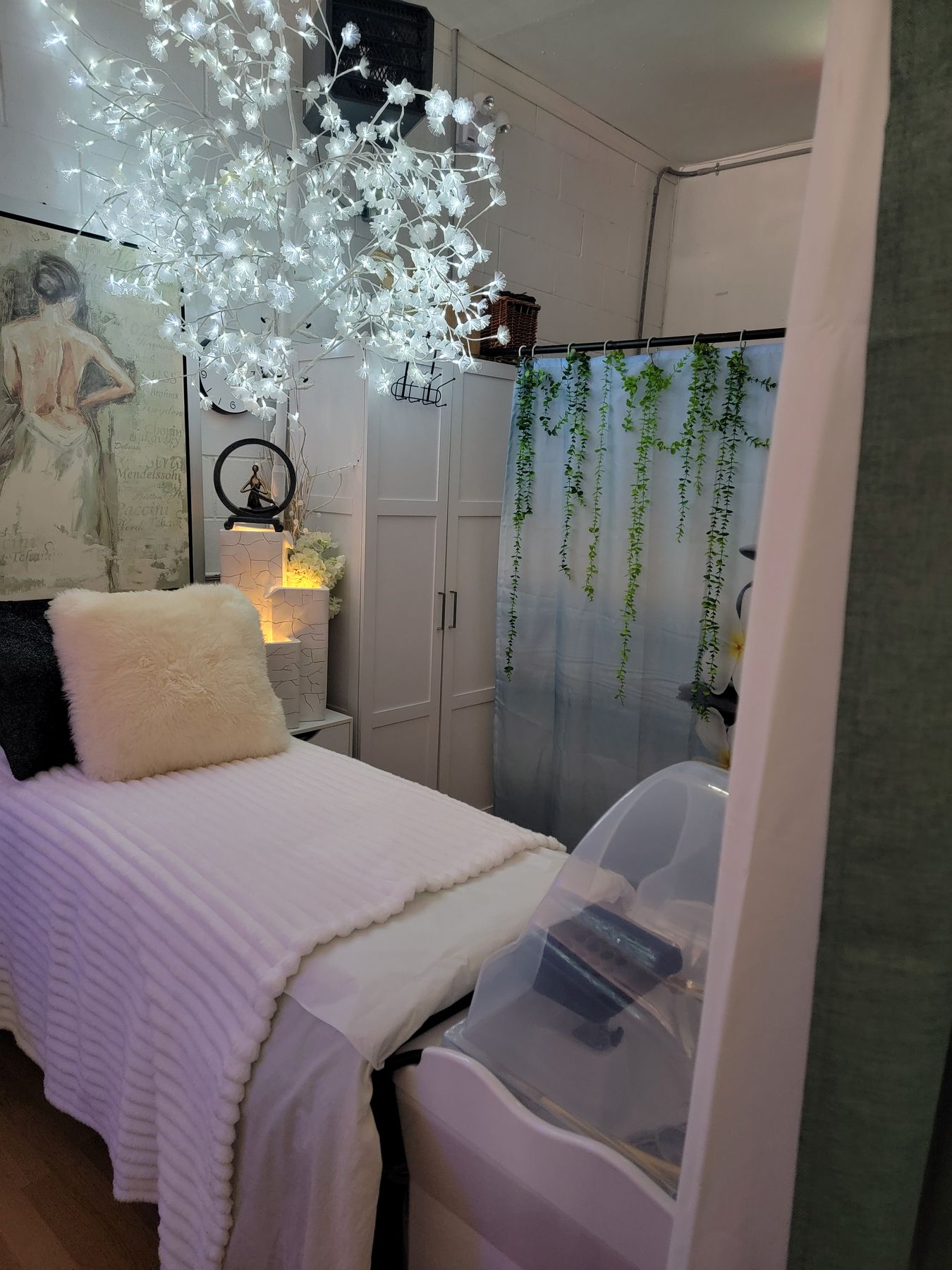 White spa room with a lit blossom tree and steam dome
